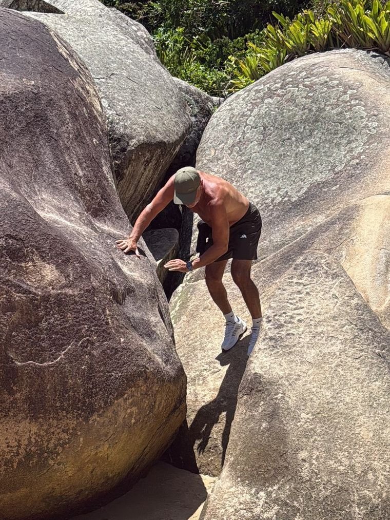 Marcelo, de 63 años, trepando una roca en la playa